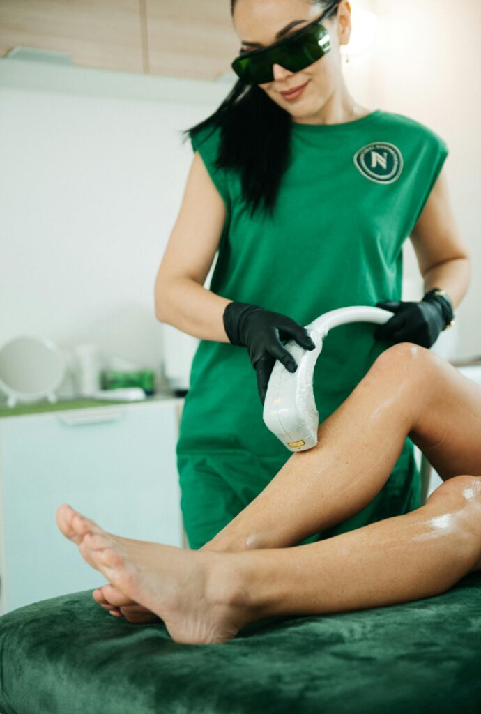 A beauty professional performing a laser hair removal session in a modern clinic.